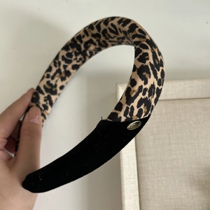 French velvet leopard print headband with a gold metal logo and stitched fabric design