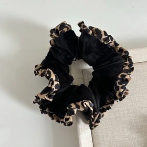 Close-up of leopard print hair scrunchie with French velvet texture and ruffled edges
