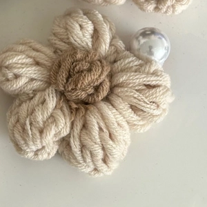 Détail d'une pince à cheveux fleur en velours faite main avec pétales crème et décoration perle