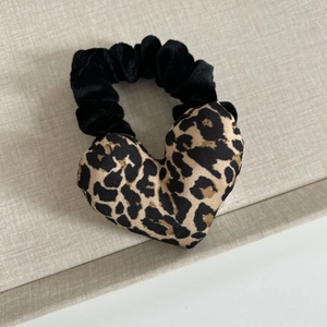 Detail of heart-shaped leopard print hair scrunchie with black velvet elastic band