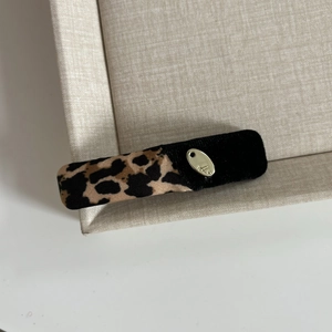 Close-up of leopard print and black velvet patchwork hair clip with gold metal plaque