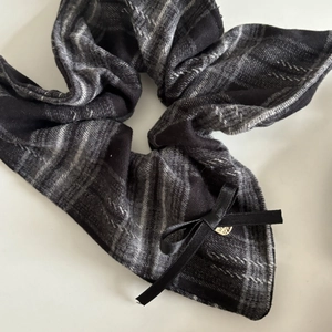 Classic black and grey plaid scrunchie with a black satin bow and golden charm detail