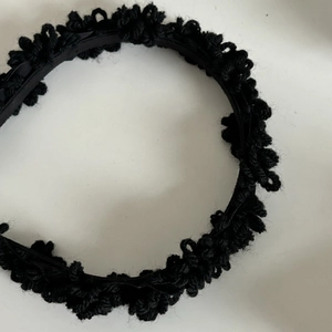 Detailansicht eines schwarzen Strick-Haarbandes mit weichem Satin-Innenfutter für den Winter