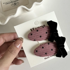 Détails de barrettes en velours côtelé rose à pois noirs et nœuds en velours
