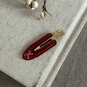 Vintage burgundy acetate bow hair clip with golden metal duckbill clamp and logo