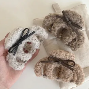 Three plush lamb wool hair claw clips with leather bows in cream, caramel and mocha brown