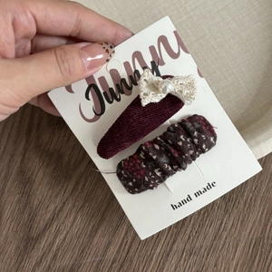Detail of two-piece hair clip set with lace bow and floral fabric on a display card