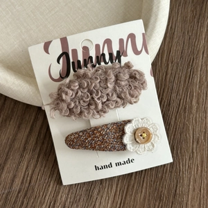Detail of handmade brown faux fur and tweed hair clips set on a gift card board