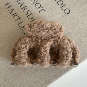 Close-up of soft brown teddy plush hair claw clip showing fuzzy texture and metal spring