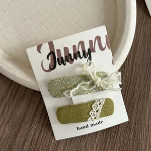 Detail of green plaid fabric hair clips with lace bows on a handmade display card