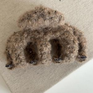 Detailed close-up of brown plush faux fur hair claw clip with soft lamb wool texture