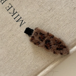 Barrette à cheveux léopard en peluche douce avec base noire sur fond de lin