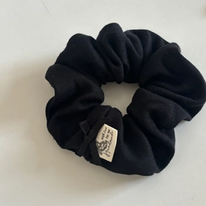 Elastic black ribbed knit hair scrunchie with satin bow and handmade teddy bear label