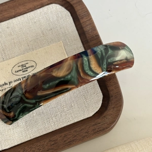 Elegante fermaglio per capelli in acetato marmorizzato verde con texture vintage in vassoio