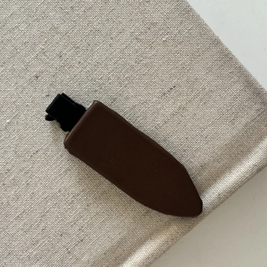 Gros plan d'une pince à cheveux motif léopard marron sur un fond en tissu texturé beige neutre