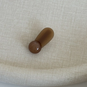 Close-up of a minimalist deep brown resin hair clip with polished spherical decor