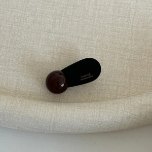 Detail of the golden France Handmade text on a dark heart hair clip with a glossy finish