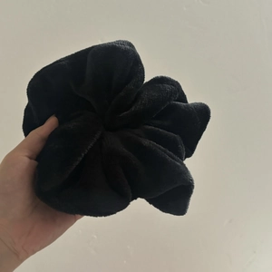 Close-up of extra large black plush scrunchie showing soft fluffy texture for women