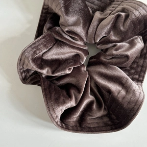 Close-up of a large French velvet scrunchie in chocolate brown with pleated texture