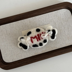 Détail macro d'une barrette à cheveux en feutre de laine en forme de bonbon au lait