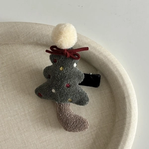 Détail d'une pince à cheveux sapin de Noël en broderie avec un petit nœud rouge