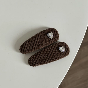 Barrettes à cheveux tricotées marron avec strass en forme de cœur sur fond blanc
