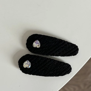 Gros plan de barrettes à cheveux en velours noir avec strass en forme de cœur