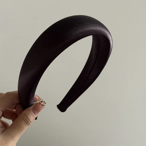 Detail shot of a dark purple wide satin padded headband with premium silk texture and thickness