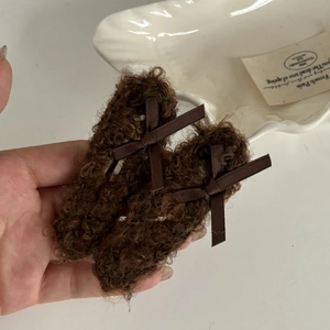 Close-up of soft brown plush bow hair clips with satin ribbon and fleece texture
