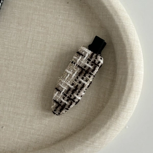 Détail de la barrette en tweed français avec motif à carreaux noir et blanc et fil doré