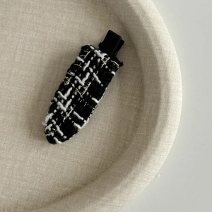 Gros plan détaillé de la pince à cheveux en tweed français avec tissage noir et blanc