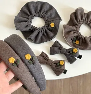 Detailed view of floral embroidery on vintage bow hair clips and scrunchies set