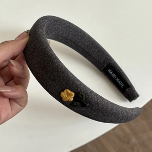 Handmade dark grey knit headband featuring elegant yellow floral embroidery patterns