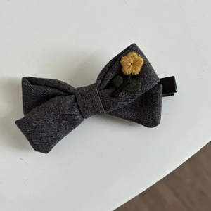 Gray woolen bow hair clip with yellow floral embroidery for elegant women hairstyle