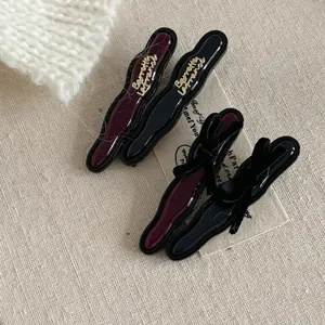 Set of four elegant acetate hair clips in red and black with bow and gold lettering