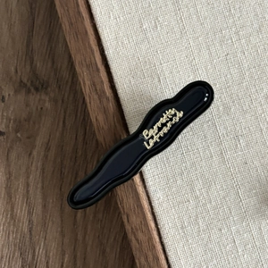 Close-up of black wavy acetate hair clip with gold Barrette La France lettering