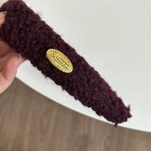 Vintage Stirnband aus weinroter Lammwolle mit goldenem Metallanhänger und Textur