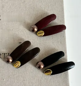 Close-up of pearl texture hair clips with PARIS metal plate and vintage bronze beads