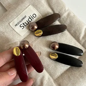 Three vintage French pearl leather clips in dark brown and burgundy with gold PARIS logo
