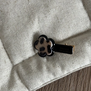 Detailed close-up of a leopard print flower hair clip with France Handmade engraving