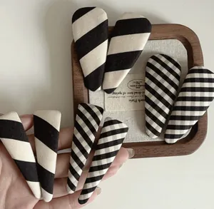 Close-up of fabric-covered teardrop hair clips with striped and checkered patterns