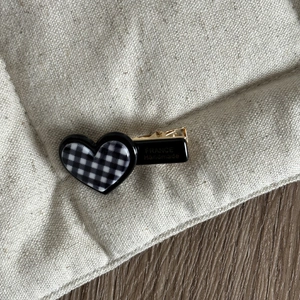 Elegant heart-shaped checkered hair clip with black and white acetate and gold metal grip