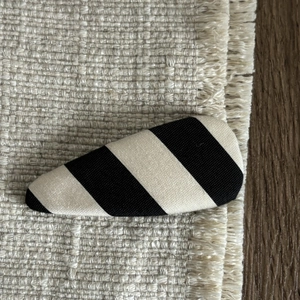 Cute black and white striped fabric BB hair clip for women on minimalist textured background