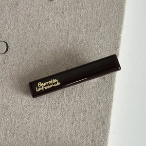 Detail view of coffee-colored resin hair clip with gold Barrette La France lettering