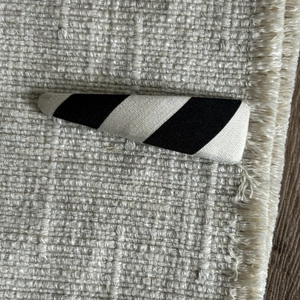 Detail of fabric wrapped snap hair clip with classic black and white diagonal stripes