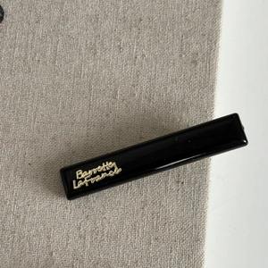 Macro detail of glossy black hair clip with elegant gold Barrette La France lettering