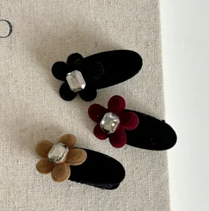 Details von drei Samtblumen-Haarspangen mit Strasssteinen in Schwarz, Rot und Khaki