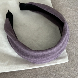 Détail du serre-tête large en velours violet sur sac en tissu montrant sa texture douce