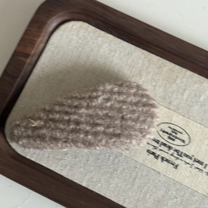 Macro detail of brown plush knit BB hair clip with soft fuzzy texture for autumn