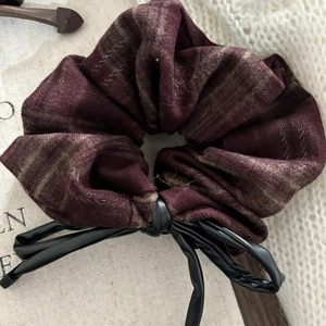 Pink checkered hair scrunchie with a black leather bow decoration for women